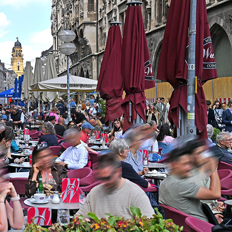 Viele M&uuml;nchner genie&szlig;en auch Regenpausen gerne im Freien, wie hier am Marienplatz.