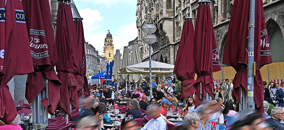 Viele M&uuml;nchner genie&szlig;en auch Regenpausen gerne im Freien, wie hier am Marienplatz.
