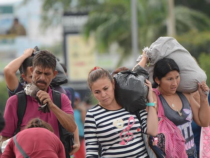 Venezolaner tragen ihre in Kolumbien getätigten Einkäufe über die Grenzbrücke zurück nach Venezuela.
