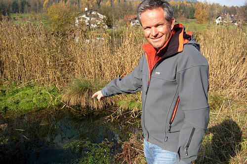 Der Salzburger Geologe Gerald Valentin zeigt auf einen mit Wasser gefüllten Krater.