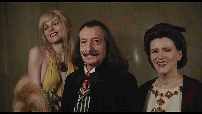 Amanda Lear (Andreja Pejic, links) ist eine gute Freundin von Dalí (Sir Ben Kingsley), neben ihm Gala (Barbara Sukowa), seine Ehefrau.