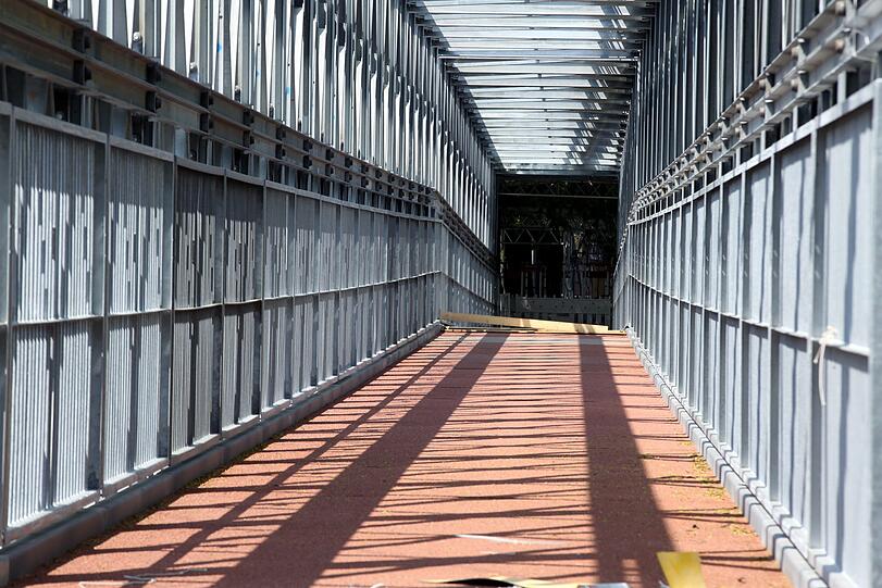 Hereinspaziert: die käfigartige Fußgängerbrücke mit Blick Richtung Innenstadt, verschwindet rechts beim Vater-Rhein-Brunnen.