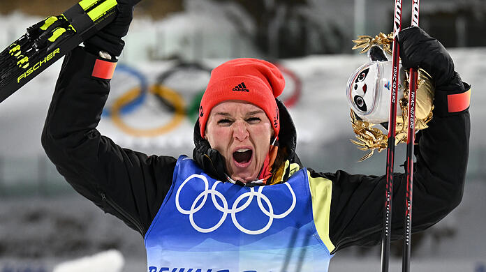 Biathletin Denise Herrmann bejubelt bei der Flower Ceremony den Gewinn ihrer Goldmedaille.
