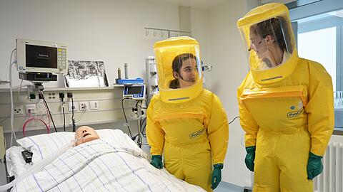 In Schutzanz&uuml;gen arbeiten die &Auml;rzte auf der Sonderisolierstation am Patienten - hier eine Puppe.
