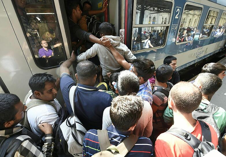 Immer mehr Flüchtlinge drängen in den ohnehin überfüllten Zug.