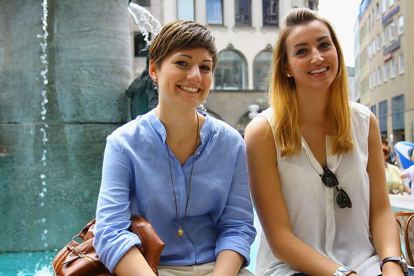 Das sind Marlene und Isabella aus München. Sie warten auf niemanden, sondern beobachten das bunte Treiben rund um den Brunnen.