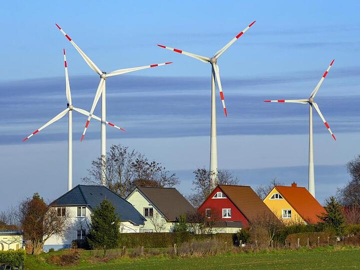Windräder hinter Einfamilienhäusern bei Jacobsdorf in Brandenburg.