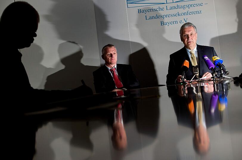 Der bayerische Innenminister Joachim Herrmann (r - CSU) spricht am 25.02.2014 während einer Pressekonferenz im bayerischen Landtag in München zu dem aktuellen Drogenskandal bei der Polizei in Kempten. Neben ihm sitzt sein Pressesprecher Oliver Platzer.