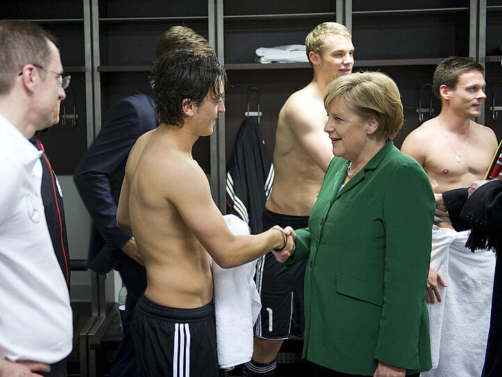 Angela Merkel in der Kabine der DFB-Elf mit Mesut Özil