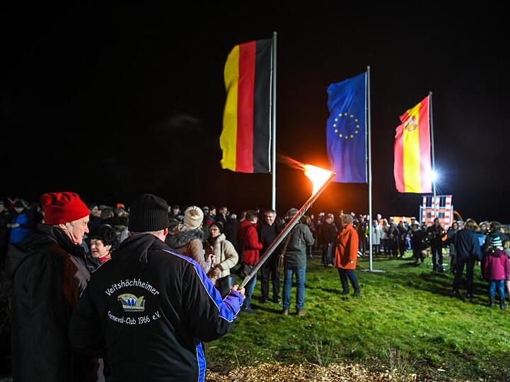 Mehrere hundert Menschen stehen in Gadheim unter den Flaggen Deutschlands, der Europäischen Union und Veitshöchheims.