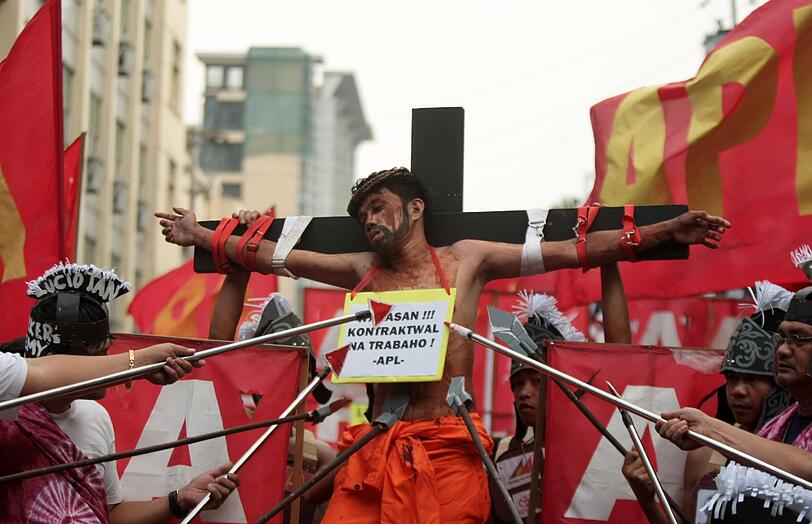 Ein Filipino hat sich ans Kreuz schnallen lassen, andere stechen mit Lanzen auf ihn ein. Jedes Jahr lassen sich dort zahlreiche Menschen kreuzigen.