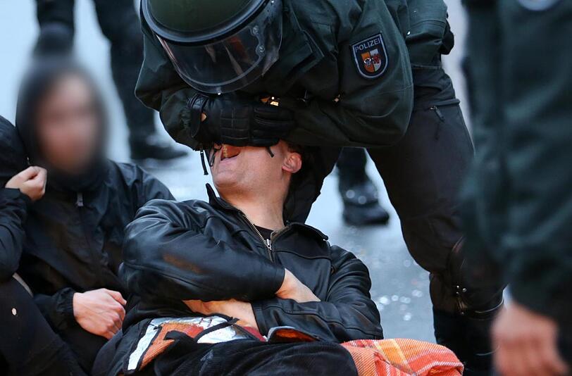 Ein Mann beißt einen Polizisten in den Arm.