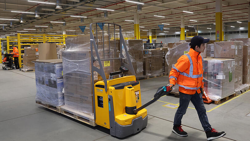 In der Warenannahme von Amazon sind Mitarbeiter mit elektrischen Hubwagen unterwegs. Wer in Elternzeit geht, erhält von Amazon eine Einmalzahlung. In der Warenannahme von Amazon sind Mitarbeiter mit elektrischen Hubwagen unterwegs. Wer in Elternzeit geht, erhält von Amazon eine Einmalzahlung.