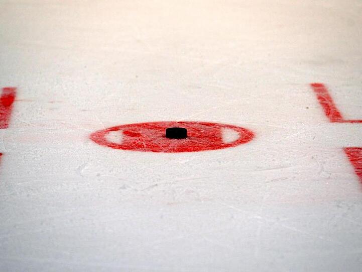 Ein Puck liegt auf dem Eis zum Bully bereit. Foto: Thomas Eisenhuth/dpa-Zentralbild/dpa/Archivbild