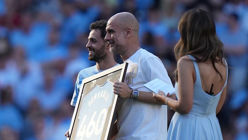 Bernardo Silva (l) und Trainer Pep Guardiola während einer Zeremonie nach ihrem letzten Spiel für Manchester City. Bernardo Silva (l) und Trainer Pep Guardiola während einer Zeremonie nach ihrem letzten Spiel für Manchester City.