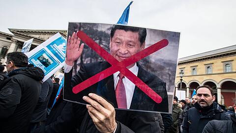 In München leben viele Exil-Uiguren. Hier protestieren sie 2019 mit einem Foto des Präsidenten Xi Jinping gegen die Verfolgung dieser ethnischen Gruppe in China.