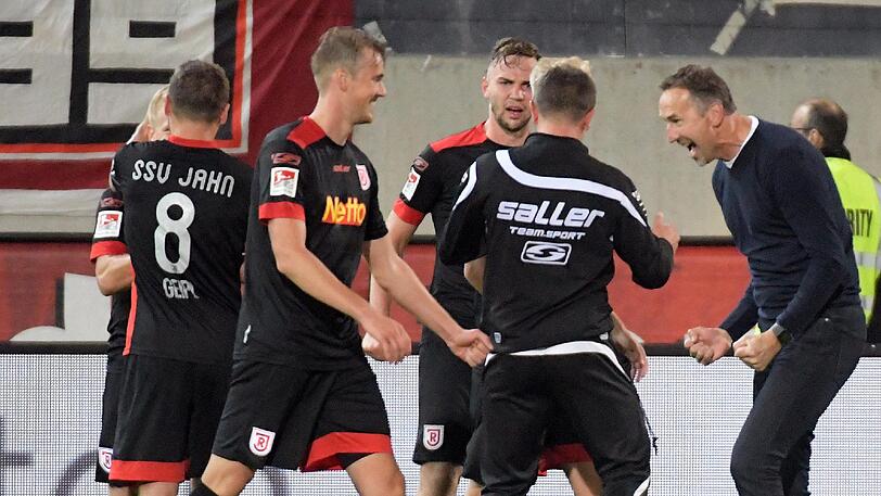 Regensburgs Trainer Achim Beierlorzer (r.) feiert mit seinen Spielern den Auswärtssieg. Heidenheim verlor mit 1:3.