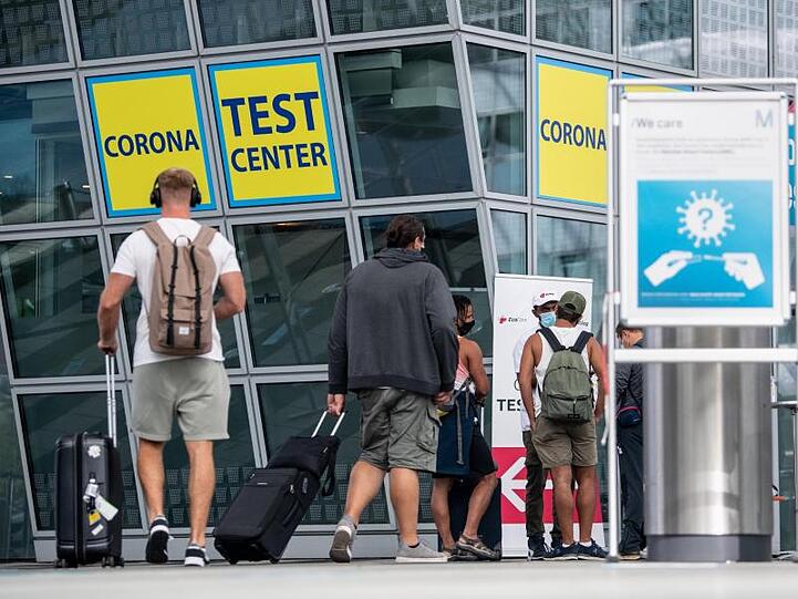 Ankommende Fluggäste gehen zu einem Corona-Testcenter am Flughafen München.