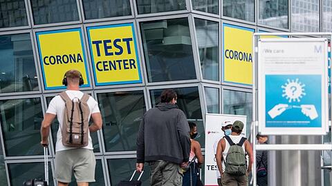 Ankommende Fluggäste gehen zu einem Corona-Testcenter am Flughafen München.
