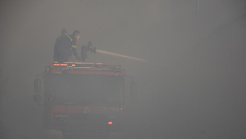 In dichten Rauch gehüllt versuchen Feuerwehrleute, die letzten Glutnester zu löschen.