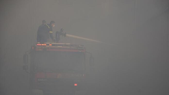 In dichten Rauch gehüllt versuchen Feuerwehrleute, die letzten Glutnester zu löschen.