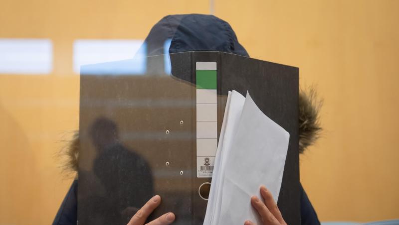 Die Angeklagte verbirgt im Düsseldorfer Oberlandesgericht ihr Gesicht hinter einem Aktenordner. Die Angeklagte verbirgt im Düsseldorfer Oberlandesgericht ihr Gesicht hinter einem Aktenordner.