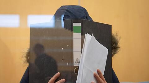 Die Angeklagte verbirgt im Düsseldorfer Oberlandesgericht ihr Gesicht hinter einem Aktenordner.