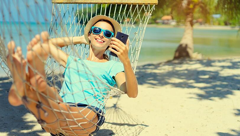 Ein Selfie machen, es für Freunde hochladen, auf Kommentare reagieren, und, und, und: Auch im Urlaub lösen sich viele Deutsche nur schwer vom Display.