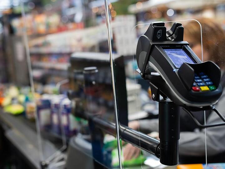 Eine Frau an einer Kasse in einem Supermarkt. Rund eine Million Menschen müssen in Deutschland ihr niedriges Einkommen mit Hartz IV aufstocken.