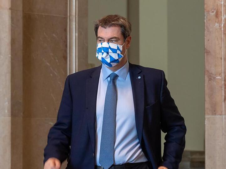Markus Söder (CSU), Ministerpräsident von Bayern, kommt mit einer Mundschutzmaske mit bayerischem, weißblauen Rautendesign zu einer Sitzung des bayerischen Landtags. Foto: Peter Kneffel/dpa/Archivbild
