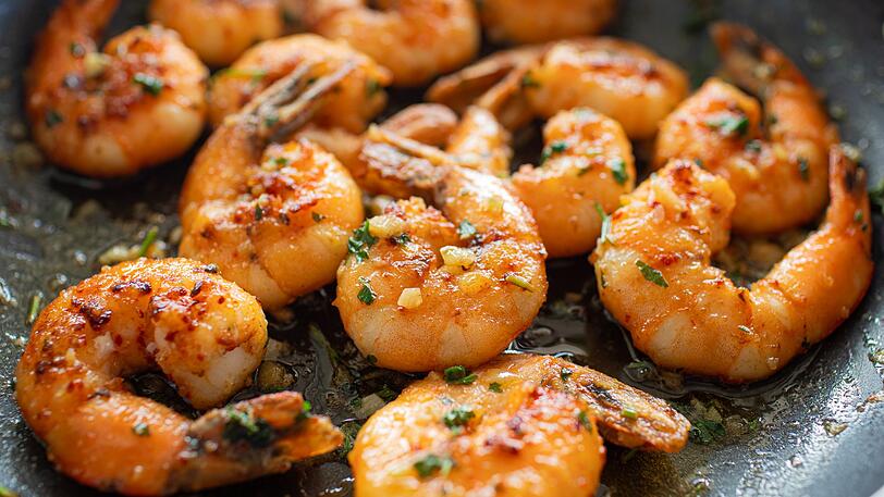 Für eine One-Pot-Shrimps-Pasta erhitzen Sie zunächst einen Esslöffel Olivenöl in einem Topf. Dünsten Sie eine fein gewürfelte kleine Zwiebel und zwei gehackte Knoblauchzehen für etwa zwei bis drei Minuten in dem Topf an, bis sie glasig sind. Danach fügen Sie 300 Gramm rohe Garnelen hinzu und braten diese ein bis zwei Minuten leicht an, bis sie rosa werden. Dann gießen Sie 400 Milliliter Gemüsebrühe dazu und geben den Saft sowie den Abrieb einer großen Zitrone hinzu. Für eine One-Pot-Shrimps-Pasta erhitzen Sie zunächst einen Esslöffel Olivenöl in einem Topf. Dünsten Sie eine fein gewürfelte kleine Zwiebel und zwei gehackte Knoblauchzehen für etwa zwei bis drei Minuten in dem Topf an, bis sie glasig sind. Danach fügen Sie 300 Gramm rohe Garnelen hinzu und braten diese ein bis zwei Minuten leicht an, bis sie rosa werden. Dann gießen Sie 400 Milliliter Gemüsebrühe dazu und geben den Saft sowie den Abrieb einer großen Zitrone hinzu.