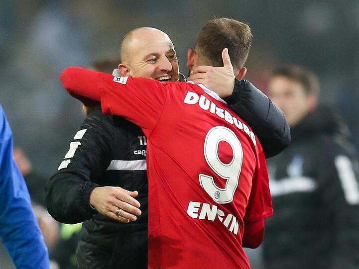 Duisburgs Torschütze Ahmet Engin (r) umarmt nach dem Abpfiff Trainer Torsten Lieberknecht.