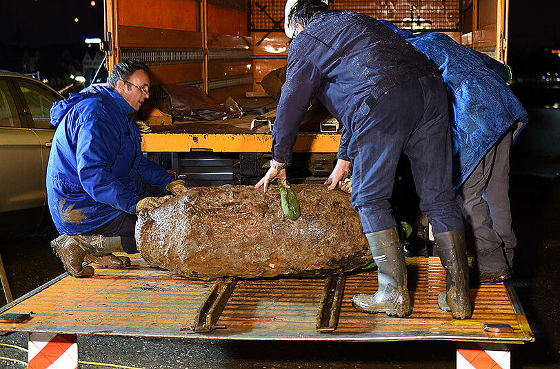 Arbeiter sichern in Köln kurz nach Mitternacht eine entschärfte Fliegerbombe aus dem Zweiten Weltkrieg auf einen Lastwagen. Der Blindgänger war nachmittags von Arbeitern am neuen Rheinboulevard zufällig gefunden worden.