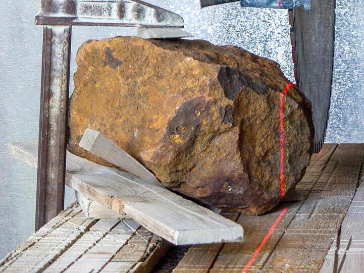 Der Meteorit liegt auf einer Werkbank. Foto: Gabriele Heinlein/Deutsches Zentrum für Luft- und Raumfahrt/dpa