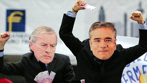 Zwei Attac-Aktivisten mit Masken der Vorstandsvorsitzenden der Deutschen Bank, Anshu Jain (r) und Jürgen Fitschen, demonstrieren im November 2013 vor dem Veranstaltungsort der «Euro Finance Week», dem Congress Center in Frankfurt am Main (Hessen). Die 16. Euro Finance Week gilt als das größte Branchentreffen der Finanz- und Versicherungsindustrie in Europa. Zwei Attac-Aktivisten mit Masken der Vorstandsvorsitzenden der Deutschen Bank, Anshu Jain (r) und Jürgen Fitschen, demonstrieren im November 2013 vor dem Veranstaltungsort der «Euro Finance Week», dem Congress Center in Frankfurt am Main (Hessen). Die 16. Euro Finance Week gilt als das größte Branchentreffen der Finanz- und Versicherungsindustrie in Europa.