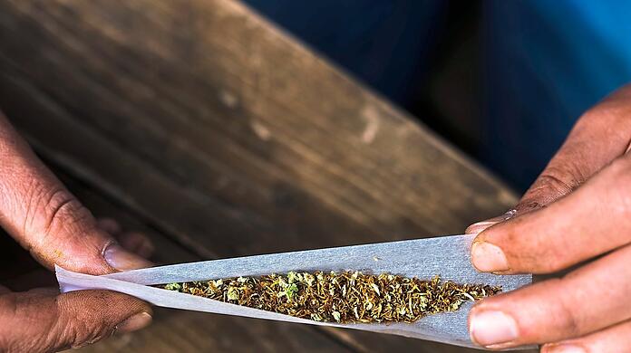 Vor einem Jahr hat es die Ampel legalisiert: Eine Person dreht Tabak und Cannabis in ein Zigarettenpapier. 365 Tage nach Inkrafttreten der neuen Regelungen zu Cannabis lässt sich eine erste Bilanz ziehen.