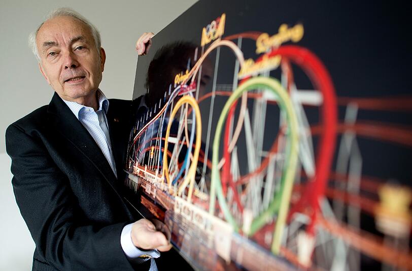 &bdquo;Godfather of Coaster Design&ldquo; und nicht &bdquo;Pate des organisierten Erbrechens&ldquo; durch seine organischen &bdquo;Herzenslinien&ldquo;-Konstruktionen: Werner Stengel in seinem Büro mit einem Foto des Olympia-Looping.