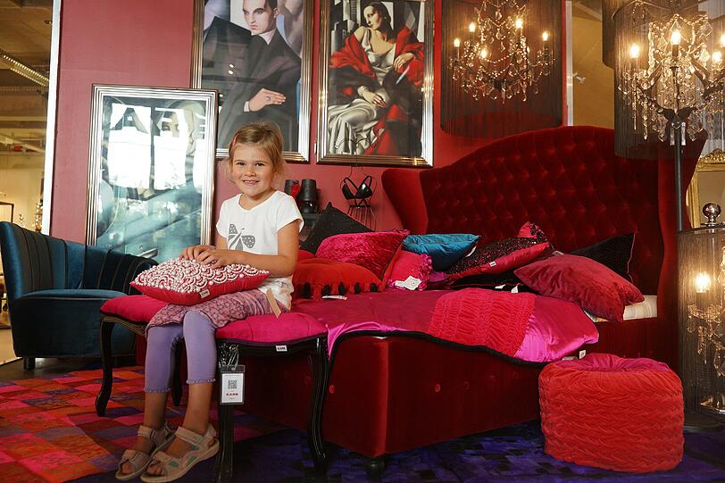 Die fünfjährige Emma hat schon das magentarote Prinzessinenbett entdeckt.