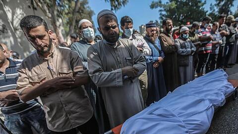 Bei der Bestattungszeremonie trauern Menschen vor dem in ein Tuch gewickelten Leichnam eines Palästinensers, der bei einem israelischen Luftangriff getötet wurde.