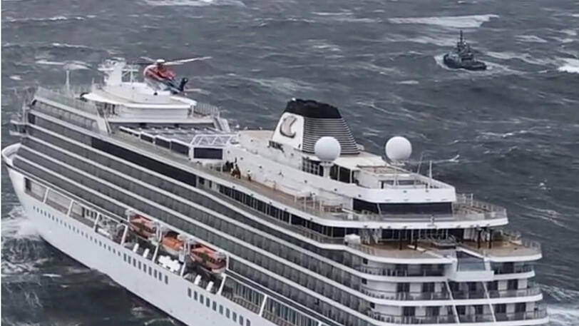 Ein Helikopter fliegt über der "Viking Sky". Das Schiff ist vor Norwegen in Seenot geraten.