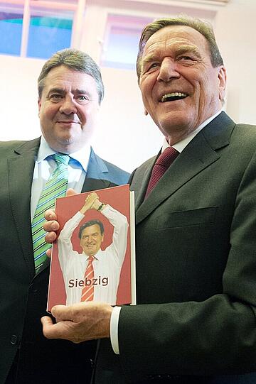 Geschenk zum 70.: SPD-Chef Sigmar Gabriel überreicht Ex-Kanzler Gerhard Schröder am 6. April 2014 in Berlin beim Empfang zu seinen Ehren ein Buch. Auf dem Titel: Gerhard Schröder.