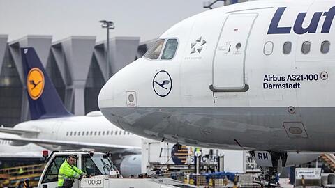 Ein Diesel-Schlepper zieht einen Airbus der Lufthansa von seiner Position am Fluggaststeig in Frankfurt.