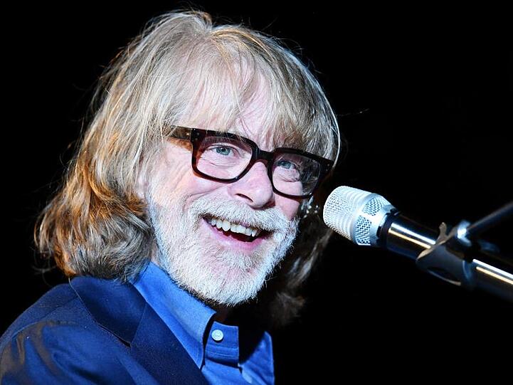 Helge Schneider, Komiker und Musiker, lacht auf der Bühne. Foto: Uwe Anspach/dpa/Archivbild