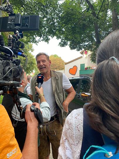 Ralf Moeller gibt Interviews, während Arnie mit Freundin Heather im Zelt verschwindet