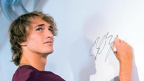 Alexander Zverev signiert während der Pressekonferenz der European Open in Hamburg eine Wand.