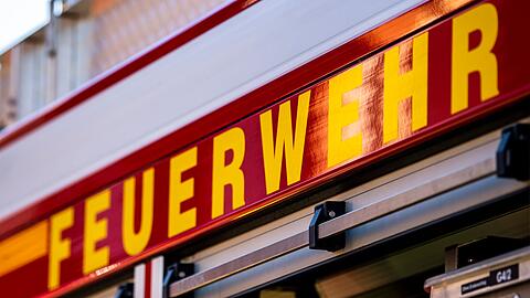 Auf dem Einsatzfahrzeug ist in gelber Farbe der Schriftzug "Feuerwehr" zu lesen.