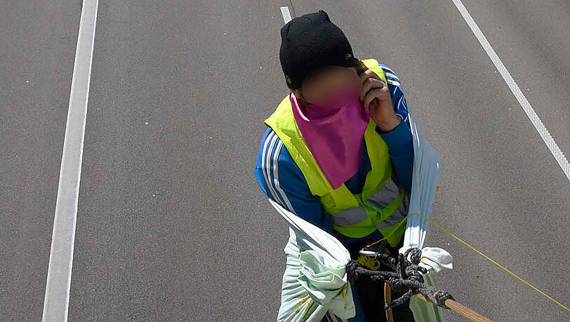 Über der gesperrten Autobahn hängend gab er am Dienstag per Smartphone Interviews. Über der gesperrten Autobahn hängend gab er am Dienstag per Smartphone Interviews.