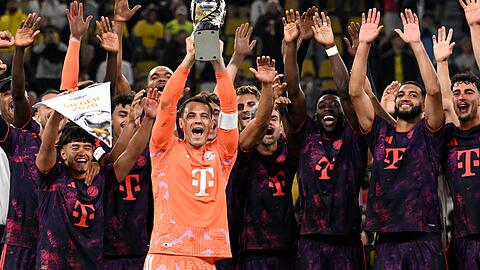 Da ist das Ding! Manuel Neuer streckt den Franz-Beckenbauer-Supercup in den Dortmunder Nachthimmel.