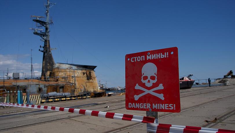 Am Hafen der zerstörten ukrainischen Stadt Mariupol warnt ein Schild vor Minen. Am Hafen der zerstörten ukrainischen Stadt Mariupol warnt ein Schild vor Minen.