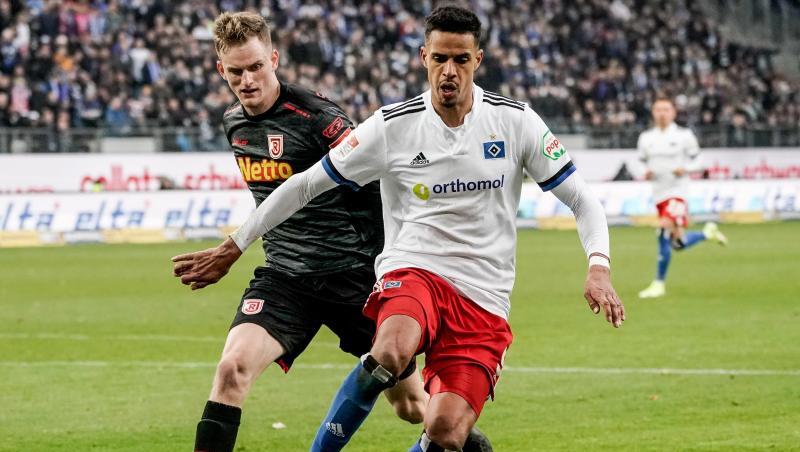 Regensburgs Scott Kennedy (l) und Hamburgs Robert Glatzel kämpfen um den Ball.